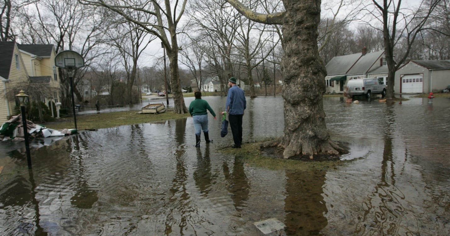 people wading through flooded street